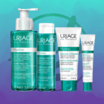 Quatre produits Uriage Hyseac Les Essentiels Pour Soins Anti Boutons Et Points Noirs, dont le Gel Moussant 50 ml, se tiennent debout dans un emballage vert et blanc sur fond bleu-vert. Dakar