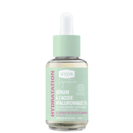 Un flacon compte-gouttes de Waam Sel Rose de l'Himalaya Bain et Gommage à 3% d'acide hyaluronique et Waam Sel Rose. L'étiquette vert menthe indique « Hydratation » et « Cosmos Organic ». Le flacon contient 30 ml. Dakar