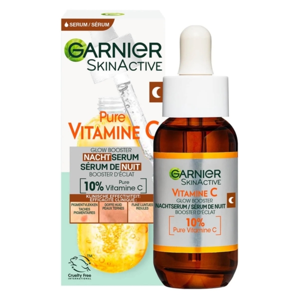 Un flacon de Garnier Skin Naturals Sérum Nuit Éclaircissant à la Vitamine C Booster d'Éclat 30 ml avec un compte-gouttes, présenté devant sa boîte. L'étiquette met en avant 10 % de vitamine C pure et présente des accents orangés. Dakar