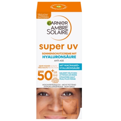 Vue de face de la boîte de Garnier Fluide Visage Solaire à l'Acide Hyaluronique SPF50+ Anti-Taches 40ml avec texte en allemand. L'emballage contient du SPF50+, de l'acide hyaluronique, de la niacinamide, en blanc, orange, bleu et or. Dakar