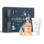 Le coffret Eau de Parfum Aqua Allegoria Rosa Rossa de Guerlain Paris comprend un grand et un petit flacon de parfum et un tube de lotion pour le corps, présentés devant une boîte bleu foncé avec des motifs dorés et le mot « Guerlain ». Dakar