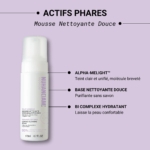 Un flacon de Nuhanciam Mousse Nettoyante Netteté et Éclat de la Peau Douce 170 ml est présenté sur un fond violet clair, avec un texte français et anglais mettant en valeur sa formule hydratante et douce et ses ingrédients actifs clés. Dakar