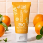 Un tube de MKL Crème mains certifiée BIO Fleur d'oranger 50ml est présenté sur une surface blanche, entouré d'oranges fraîches et de feuilles vertes, sur un fond carrelé. Dakar