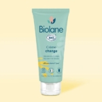 Un tube de Biolane Crème change Bébé 100ml se tient debout sur un fond jaune clair. L'emballage sarcelle, avec des accents blancs, jaunes et bleus, comporte un texte en français, un logo de certification BIO et met en avant la douceur des soins pour les bébés. Dakar