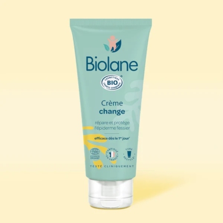 Un tube de Biolane Crème change Bébé 100ml se tient debout sur un fond jaune clair. L'emballage sarcelle, avec des accents blancs, jaunes et bleus, comporte un texte en français, un logo de certification BIO et met en avant la douceur des soins pour les bébés. Dakar