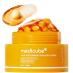 Le pot jaune ouvert de Medicube Crème en Capsules à l'Acide Kojique et au Curcuma Vita 50 g contient un gel orange et des capsules jaunes. Au-dessus, une cuillère présente une cuillère de gel et une gélule. Dakar
