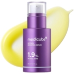 Un flacon violet de Medicube Sérum Booster Stimulant Anti Age au Rétinol Nmn 30ml est présenté devant un frottis de sérum jaune sur fond blanc. Dakar