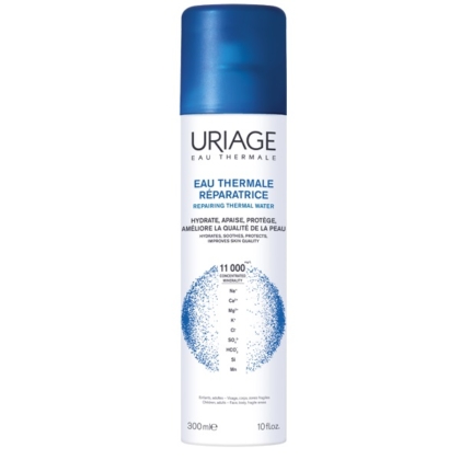 Un vaporisateur blanc et bleu de 300 ml d'eau thermale d'Uriage est doté d'un bouchon bleu et affiche les détails du produit en français et en anglais, mettant en avant ses propriétés réparatrices de l'eau thermale. Dakar