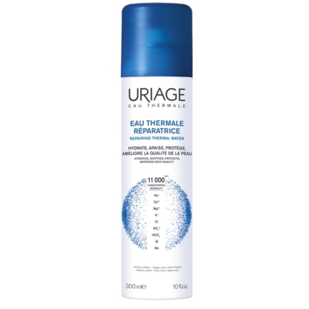 Un vaporisateur blanc et bleu de 300 ml d'eau thermale d'Uriage est doté d'un bouchon bleu et affiche les détails du produit en français et en anglais, mettant en avant ses propriétés réparatrices de l'eau thermale. Dakar