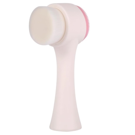 La Kojie San Brosse pour visage exfoliante pour peau parfaite est une brosse pour le visage à double face avec un manche blanc, des poils doux d'un côté, et un tampon en silicone rose texturé pour l'exfoliation. Dakar