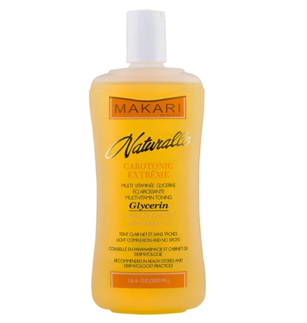 Un flacon de 500 ml de Makari Naturalle Glycérine Éclaircissant Extrême à l'Huile de Carotte, une lotion tonique multi-vitaminée avec un liquide jaune-orange et un bouchon blanc, conçue pour améliorer la tonicité et le teint de la peau. Dakar