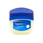 Un petit récipient étiqueté « Vaseline Cocoa Lait Hydratant Corps au Beurre de Cacao 200 ml » avec un couvercle bleu est présenté, présentant un design blanc et bleu apaisant. Dakar