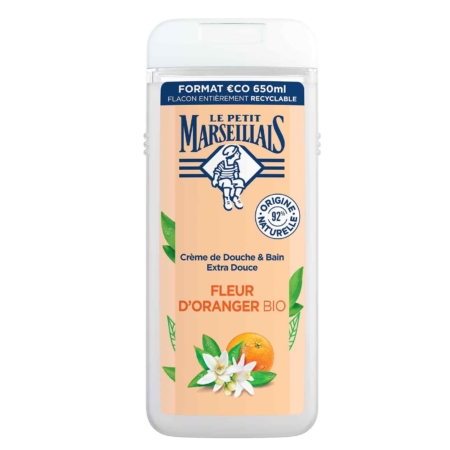 Vue de face d'une bouteille de 650 ml de la Crème de Douche Extra Douce Fleur d'Oranger BIO du Petit Marseillais. L'étiquette blanche et orange présente des fleurs, des feuilles, une orange et des symboles de recyclage écologique. Dakar