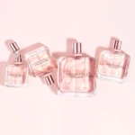 Quatre flacons carrés GIVENCHY Irresistible Eau de Parfum pour femme 35 ml, teintés de rose et munis d'un bouchon argenté réfléchissant, sont disposés sur un fond rose pâle, certains à plat, d'autres inclinés. Dakar