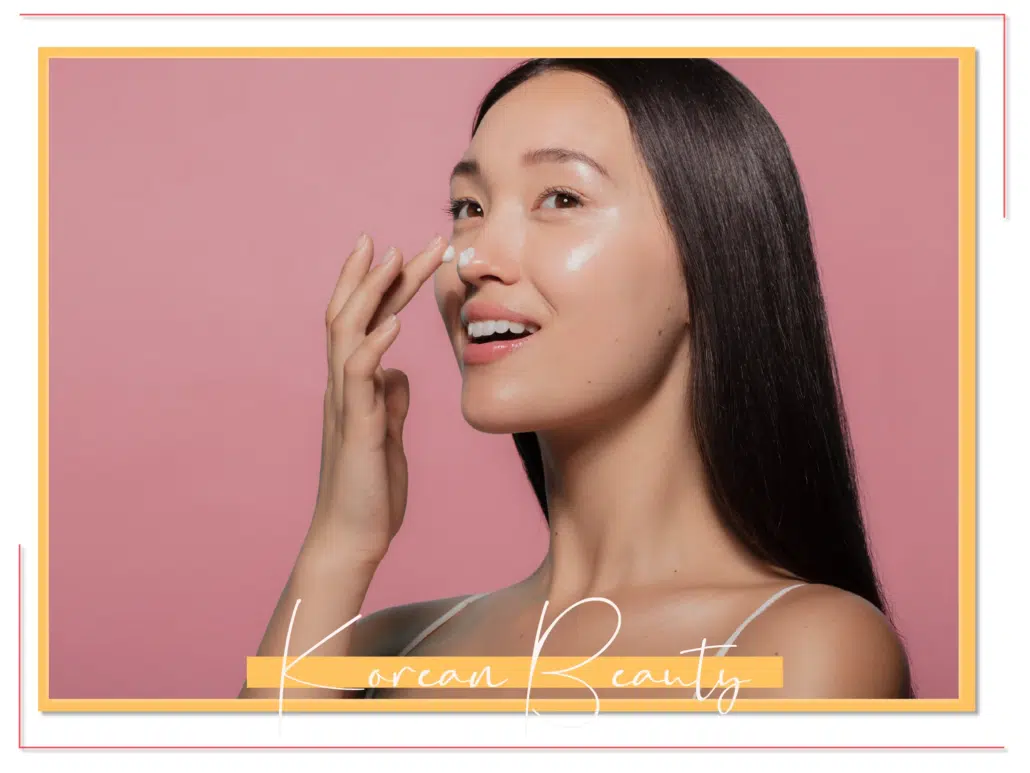 Femme aux cheveux longs applique un produit de soin sur son visage, fond rose, texte "UniversCosmetix Korean Beauty" en bas.