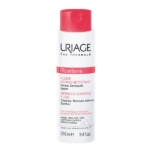Le Fluide Dermo Nettoyant Roseliane d'URIAGE 250 ml est doté d'un flacon blanc épuré avec une étiquette rouge. Ce nettoyant doux démaquille efficacement et apaise les peaux sensibles, offrant un soin délicat optimal. Dakar