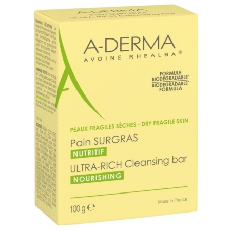 Une boîte jaune de A Derma Les Indispensables Pain Dermatologique Apaisant 100g pour les peaux sèches et fragiles, avec un texte en français et en anglais. L'emballage indique que la formule est nourrissante et biodégradable et que le produit est fabriqué en France. Dakar
