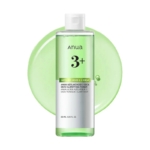 Une bouteille transparente d'Anua Azelaic Acid 3 Cica Skin Tonique Clarifiant Azélaïque Cica 250ml, remplie d'un liquide vert, est représentée avec une éclaboussure de liquide vert. Le flacon étiqueté contient 250 ml (8.45 fl. oz.). Dakar