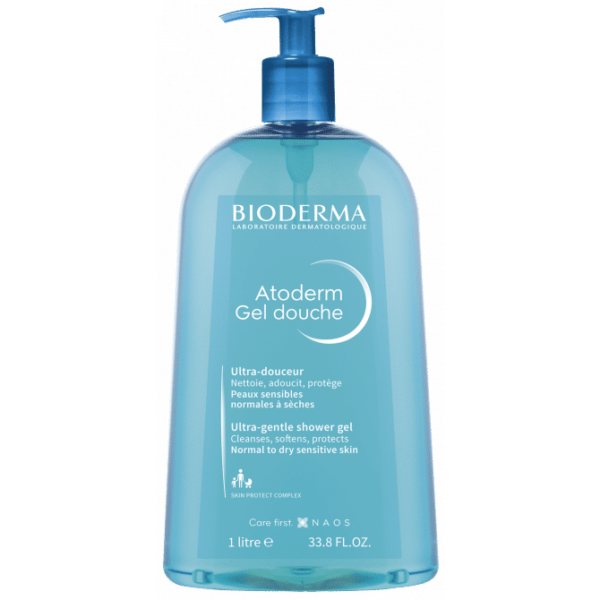 Un flacon pompe bleu de Bioderma ATODERM Gel Douche Nettoyant Douceur 1L, parfait pour la chaleur du Dakar. L'étiquette le décrit comme un gel douche ultra-doux adapté aux peaux sensibles normales à sèches. Dakar