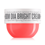 Un contenant rouge de Sol de Janeiro Bom Dia Bright Cream crème pour le corps éclat 75 ml avec une étiquette blanche