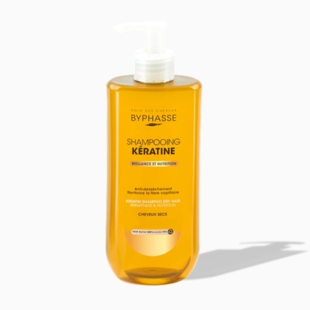 Un flacon jaune de « Shampooing à la Kératine CHEVEUX SECS ET ABÎMÉS » de Byphasse, d'une contenance de 500 ml, destiné aux cheveux secs et abîmés, muni d'une pompe blanche et portant une étiquette mettant en avant l'éclat et la nutrition, projetant une ombre sur un fond blanc. Dakar