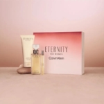 Le coffret cadeau Calvin Klein Eternity pour Femme comprend un vaporisateur de parfum, une lotion pour le corps et est livré dans une boîte de marque rose et blanche, le tout présenté sur un fond neutre avec des accents de pierre. Dakar