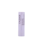 Un tube blanc de Caudalie - Soin des lèvres 4,5 g se tient debout sur un fond blanc uni, avec le nom et les détails du produit imprimés verticalement en violet sur le tube. Dakar