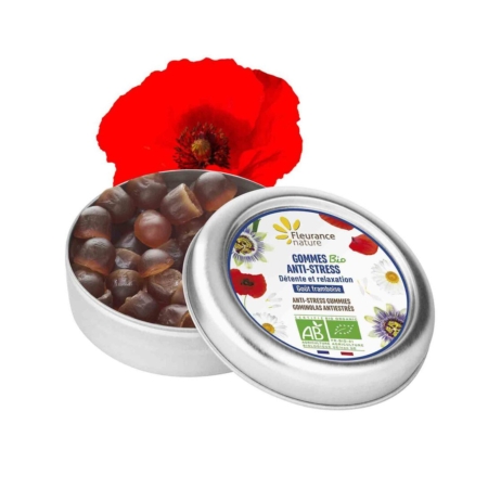 Une boîte métallique ouverte de 30 g de Fleurance Nature Gommes anti-stress Bio Complément alimentaire est présentée à côté d'un coquelicot rouge, l'étiquette florale du produit mettant en évidence ses certifications biologiques. Dakar