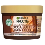 Un tube brun de Garnier Fructis Hair Food Masque Multi Usages Beurre de Kakao 390 ml avec un couvercle beige ; l'étiquette indique 97% d'origine naturelle, convient aux cheveux bouclés et secs, et fonctionne comme un masque capillaire nourrissant 3 en 1. Dakar