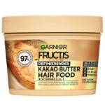 La boîte beige de Garnier Fructis Hair Food Masque Multi Usages Beurre de Kakao 390 ml présente des accents noirs et dorés, un texte en allemand pour les cheveux secs et bouclés, une formule végétalienne et une teneur en beurre de cacao. Dakar