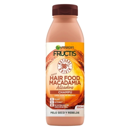 Un flacon de 400 ml de Garnier Fructis Shampooing Hair Food Macadamia pour les cheveux secs et indisciplinés, avec un bouchon marron et une étiquette orange avec les détails et les avantages du produit en espagnol. Dakar