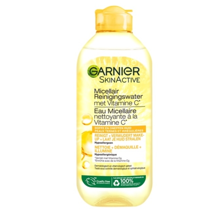 Un flacon transparent de Garnier Skin Active Vitamine C Solution Micellaire Tout en 1 400 ml, avec des accents jaunes et des textes en néerlandais et en français, est présenté sur un fond illustré d'une tranche d'agrume. Dakar