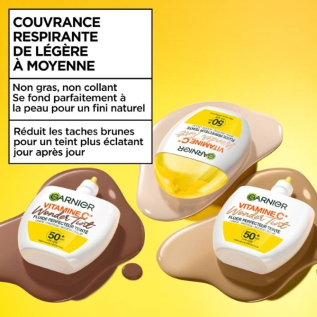 Trois flacons Garnier Vitamine C Fluide Perfecteur Teinté Spf50 Wonder Tint de 40 ml sont posés sur des blocs de couleur chair, avec un texte en français mettant l'accent sur la couvrance légère et respirante et sur l'atténuation des taches brunes pour une peau radieuse. Dakar