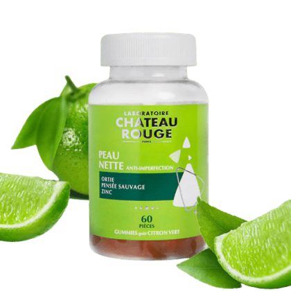 Une bouteille de Chateau Rouge Gummies Peau Nette Anti-imperfections 60 gummies avec des tranches de citron vert et un citron vert entier en arrière-plan
