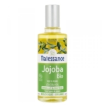 Un flacon de 50 ml d'Huile de Jojoba Régénérante Natessance avec un bouchon argenté, une étiquette verte et blanche, des images de la plante de jojoba et un texte indiquant « 100% Pure Jojoba Oil » et « Embellit & Protège ». Dakar