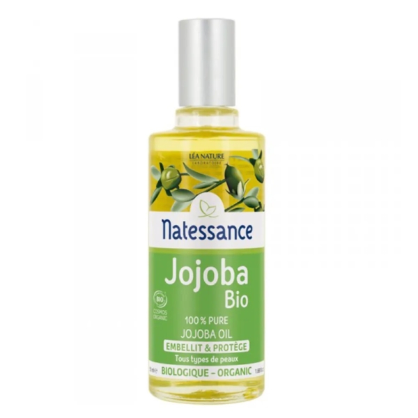 Un flacon de 50 ml d'Huile de Jojoba Régénérante Natessance avec un bouchon argenté, une étiquette verte et blanche, des images de la plante de jojoba et un texte indiquant « 100% Pure Jojoba Oil » et « Embellit & Protège ». Dakar