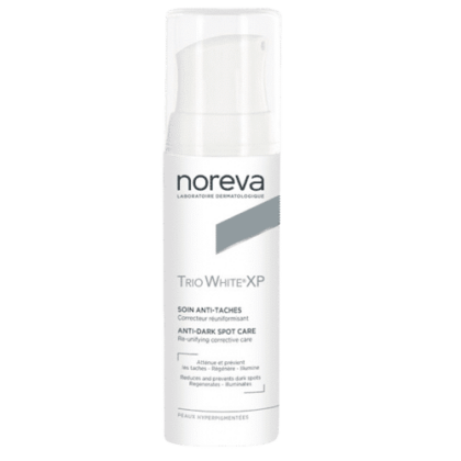 Un flacon de Noreva Trio White XP Soin Anti-Taches 30 ml avec un packaging blanc et un bouchon transparent