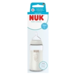Le Nuk Biberon en Verre First Choice Blanc à partir de 3 mois 240 ml est présenté dans une boîte bleue et blanche avec une fenêtre transparente. Il est doté d'une tétine en silicone et d'un design minimal avec une adorable illustration de girafe. Dakar