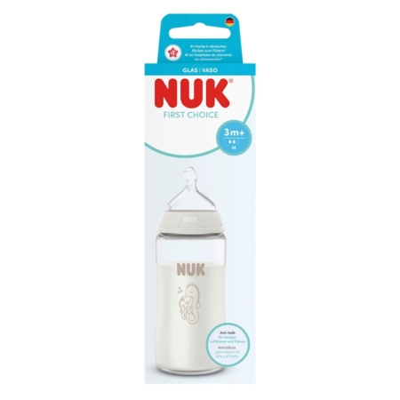 Le Nuk Biberon en Verre First Choice Blanc à partir de 3 mois 240 ml est présenté dans une boîte bleue et blanche avec une fenêtre transparente. Il est doté d'une tétine en silicone et d'un design minimal avec une adorable illustration de girafe. Dakar