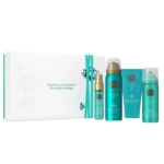 The Rituals The Ritual Of Karma Coffret Cadeau pour Femme est un coffret blanc et sarcelle comprenant quatre flacons de soin bleu-vert dans une boîte assortie, avec la citation "Le bonheur peut se trouver dans les plus petites choses". Dakar