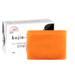Une barre de Kojie San Savon Unifiant Anti Taches Tous les Types de Peaux 135g à côté de sa boîte packaging blanche d'Univers Cosmetix