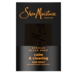 Une boîte noire de SHEA MOISTURE African Black Soap & Shea Butter Savon 230g avec "calm & clearing bar soap with plant-based moisturizers" en texte orange et le nom de la marque en haut en cursive. Dakar