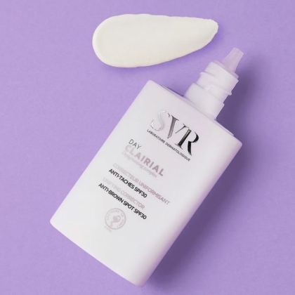Un flacon de crème SVR CLAIRIAL DAY Spf 30 Correcteur Uniformisant Anti Taches 30 ml sur fond violet