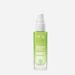 Un flacon transparent de Svr Sebiaclear Sérum Anti-Imperfections 30ml (Peaux à Tendance Acnéique) avec une pompe blanche et un liquide vert se détache sur un fond blanc uni, étiqueté pour corriger les imperfections et les marques. Dakar