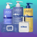 Le coffret d'Uriage Kit Complet Soins Bébé, qui comprend des produits de soins pour bébé, une éponge de bain supplémentaire, un sac et un doudou gratuit, est joliment présenté sur un fond bleu et sarcelle. Dakar