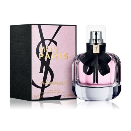 Un flacon de parfum Yves Saint Laurent Mon Paris, teinté de rose et orné d'un nœud noir, est posé à côté de sa boîte assortie, faisant écho à l'élégance chic de l'emballage de l'Eau Micellaire au Bicarbonate de Soude 300ml de Bioré. Dakar