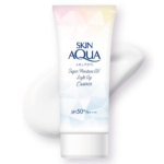 Un tube de Rohto Gel UV Super Hydratant Skin Aqua SPF50+ Crème Solaire Visage Corps 110g est présenté sur un fond blanc avec une trace de crème derrière lui, dans un emballage aux accents géométriques blancs et pastels. Dakar