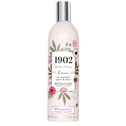 Un flacon de 100 ml de "BERDOUES MILLE FLEURS Parfum Eau de Toilette" présente un design floral avec des fleurs et des feuilles roses et blanches, avec une étiquette indiquant "94% d'ingrédients d'origine naturelle" sur fond blanc. Dakar