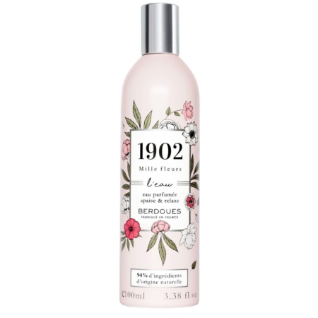 Un flacon de 100 ml de "BERDOUES MILLE FLEURS Parfum Eau de Toilette" présente un design floral avec des fleurs et des feuilles roses et blanches, avec une étiquette indiquant "94% d'ingrédients d'origine naturelle" sur fond blanc. Dakar