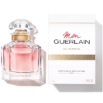 Un flacon de GUERLAIN Mon Guerlain Eau de Parfum pour femme 50 ml, au liquide rose, trône élégamment à côté de son coffret blanc aux accents dorés et au texte noir. Cette pièce fait partie du luxueux coffret de GUERLAIN, comprenant l'Eau de Toilette La Petite Robe Noire. Dakar